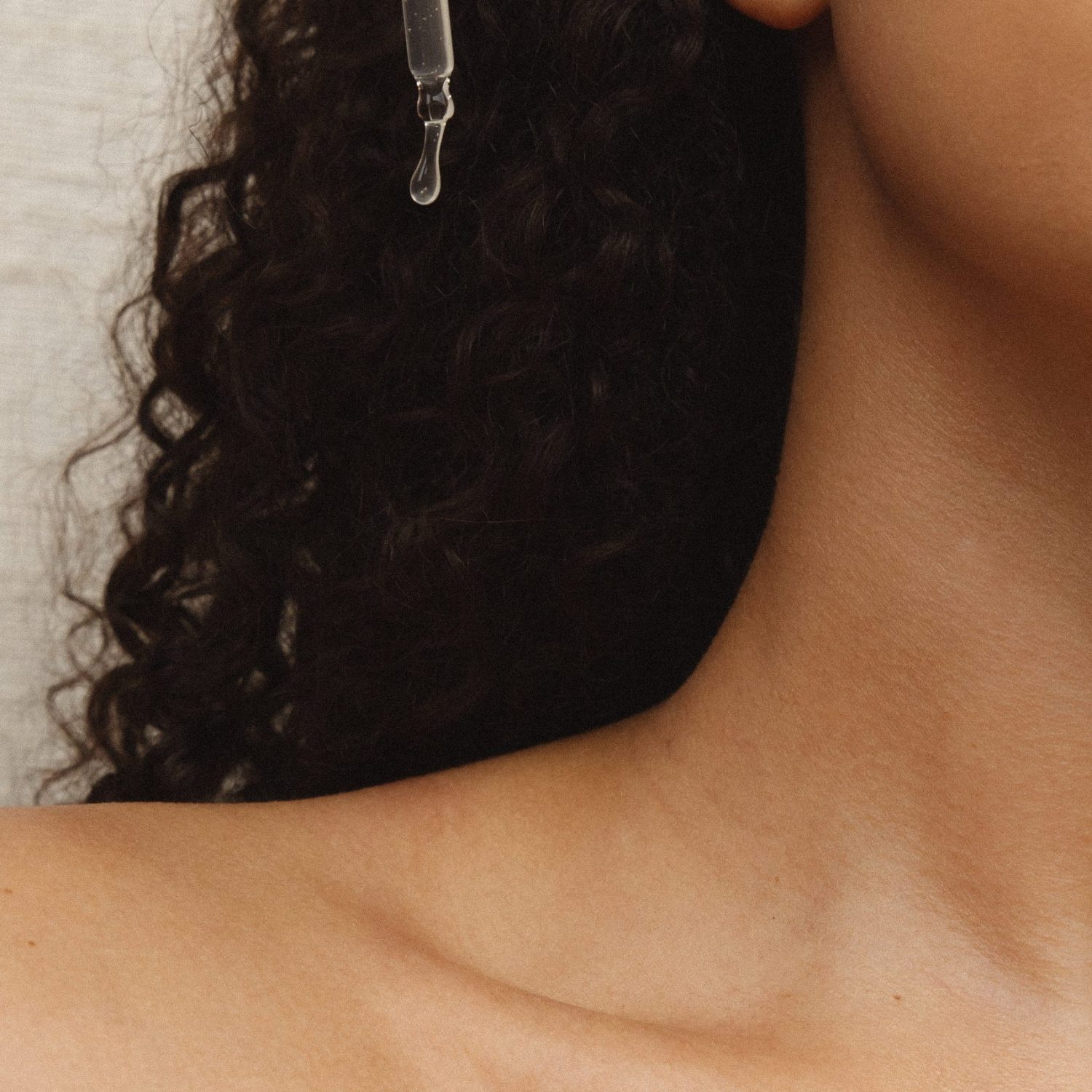 a woman's shoulder with product dropper